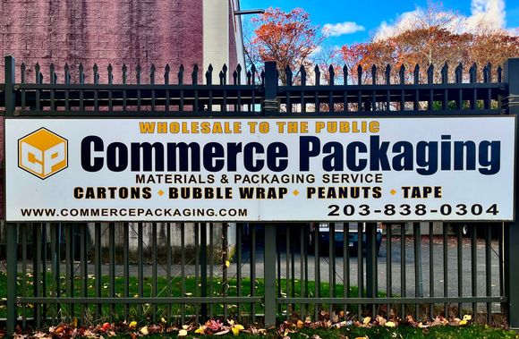 A sign on a gate on the exterior of Commerce Packaging's facilities. The sign reads 