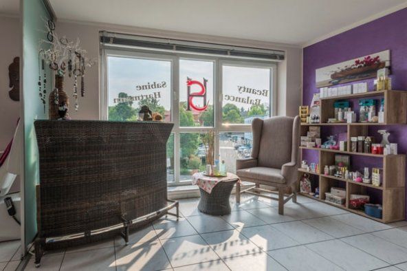 Ein Wohnzimmer mit einer lila Wand und einem Schild mit der Aufschrift „a“ darauf