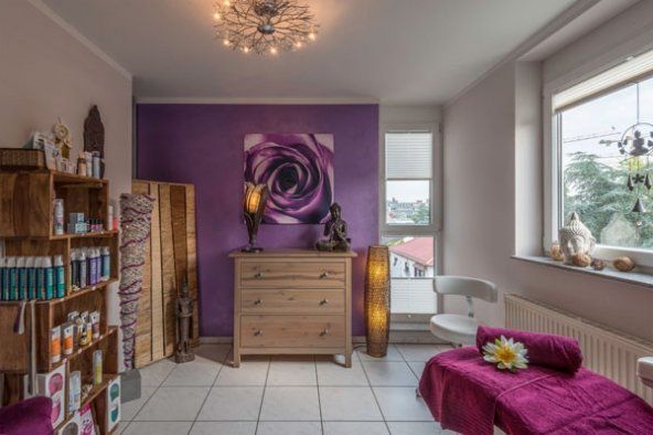 Ein Zimmer mit einer lila Wand und einem lila Sofa