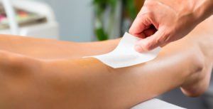 Eine Frau lässt sich in einem Schönheitssalon die Beine wachsen.