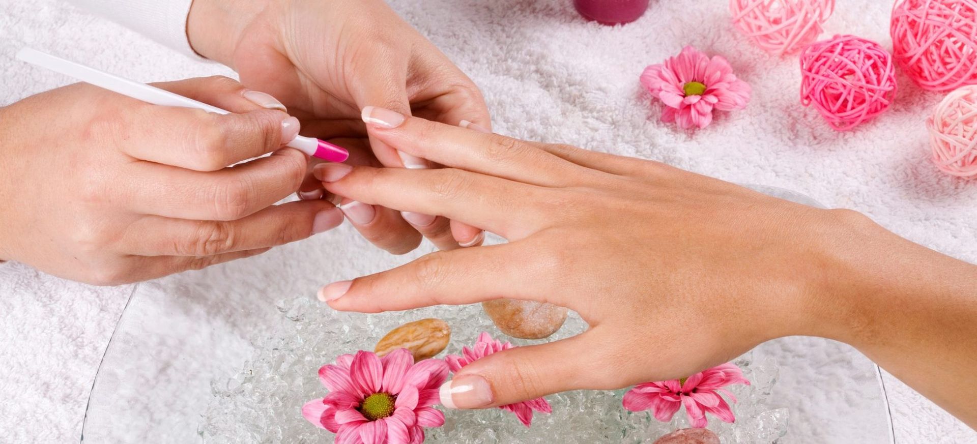 Eine Frau lässt sich von einer Nagelkünstlerin die Nägel lackieren.