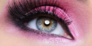 Eine Nahaufnahme des Auges einer Frau mit rosa Lidschatten.