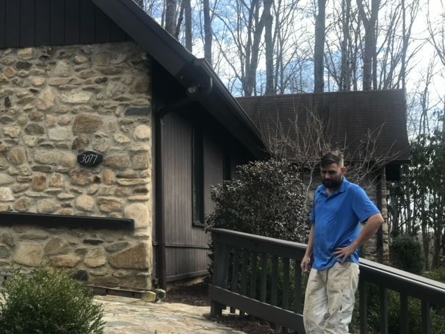 A Man In A Blue Shirt Is Standing In Front Of A Stone House – Boone, NC – A Brush Above Painting