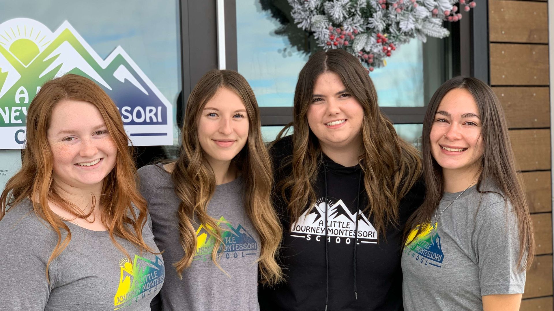 A group of young women are posing for a picture in front of a building.