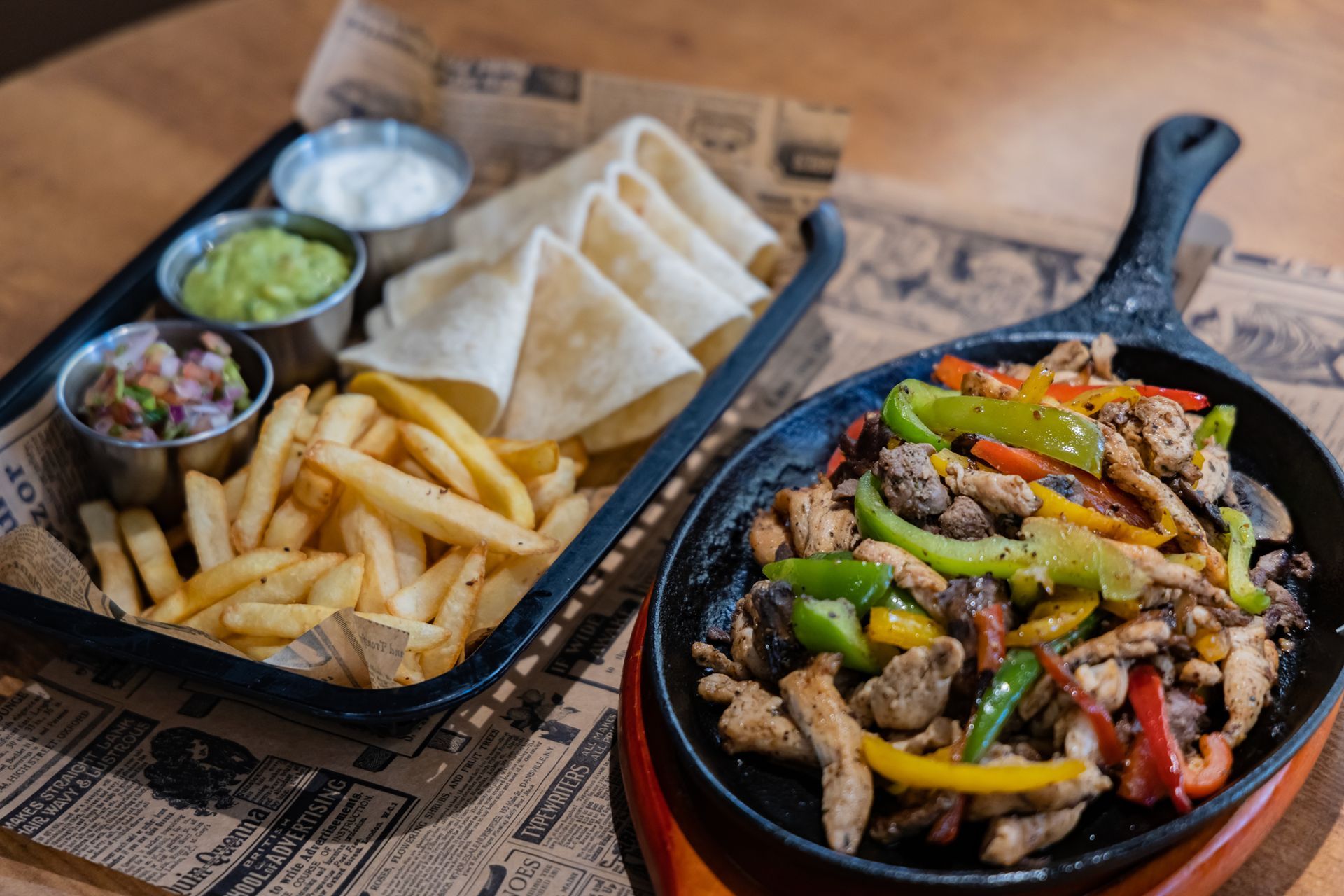 A plate of food with french fries and guacamole on a table.