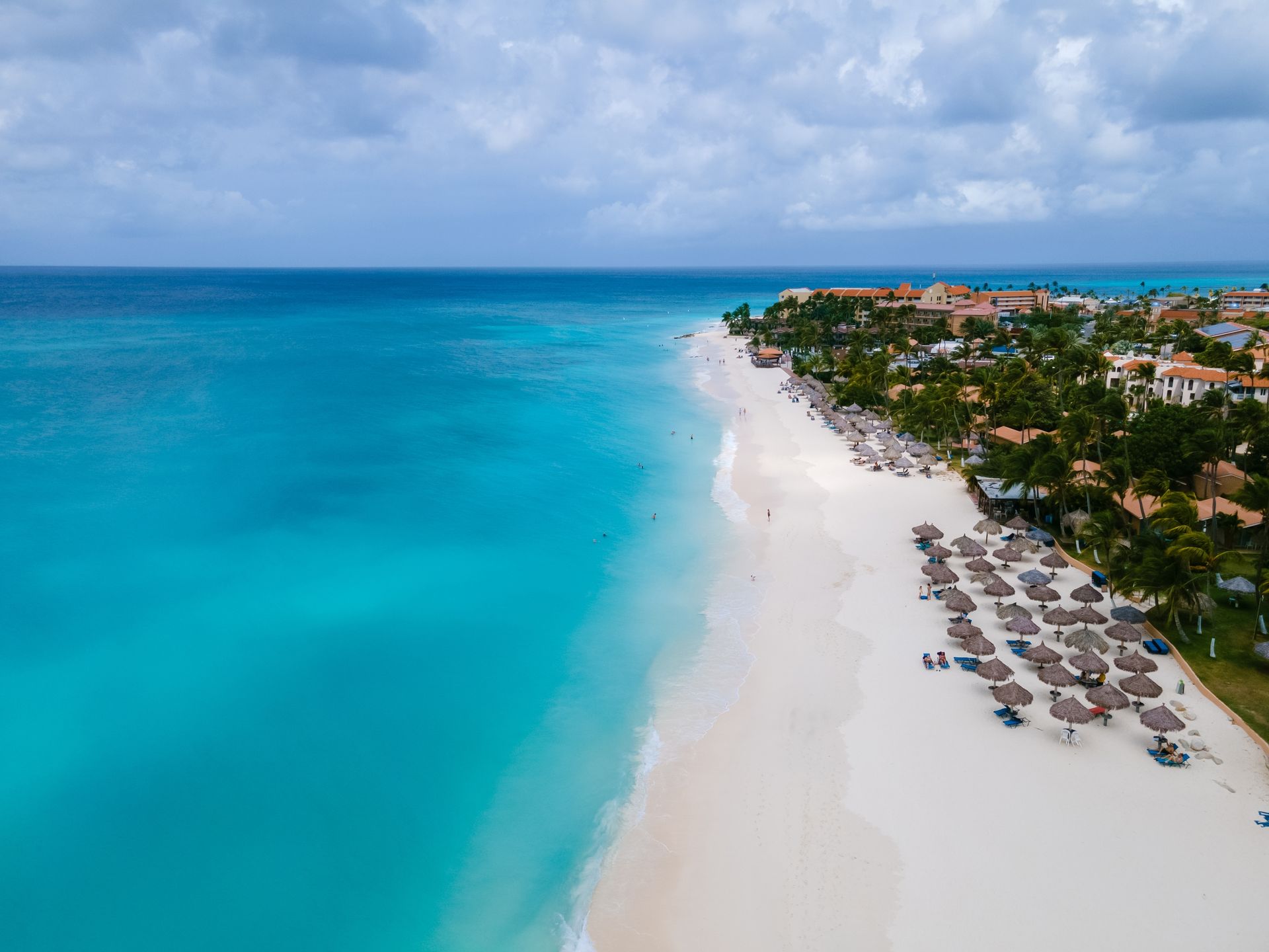 An aerial view of a beach with white sand and turquoise water.