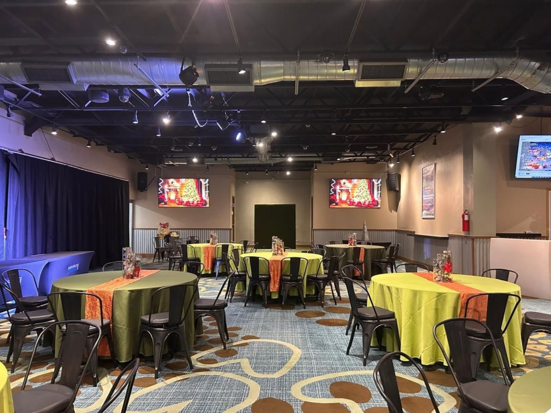 A large room with tables and chairs set up for a party.