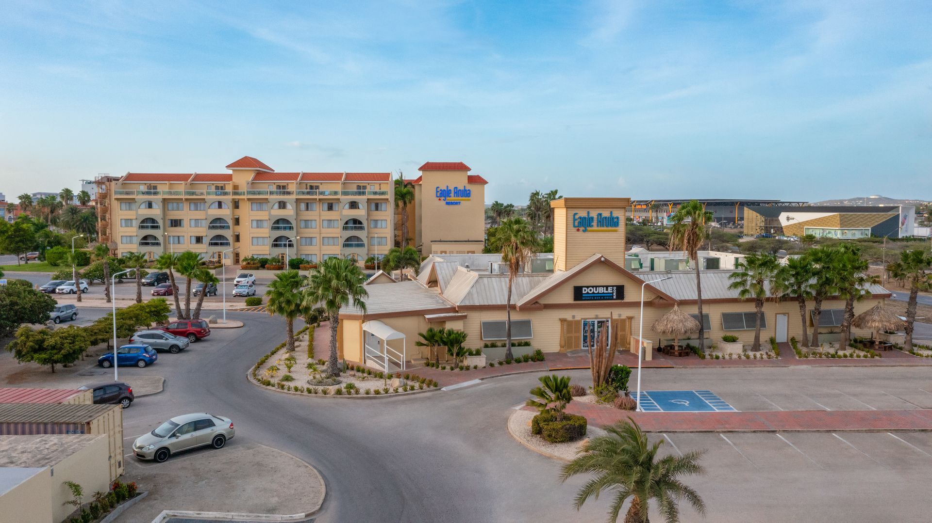 An aerial view of a hotel with cars parked in front of it.