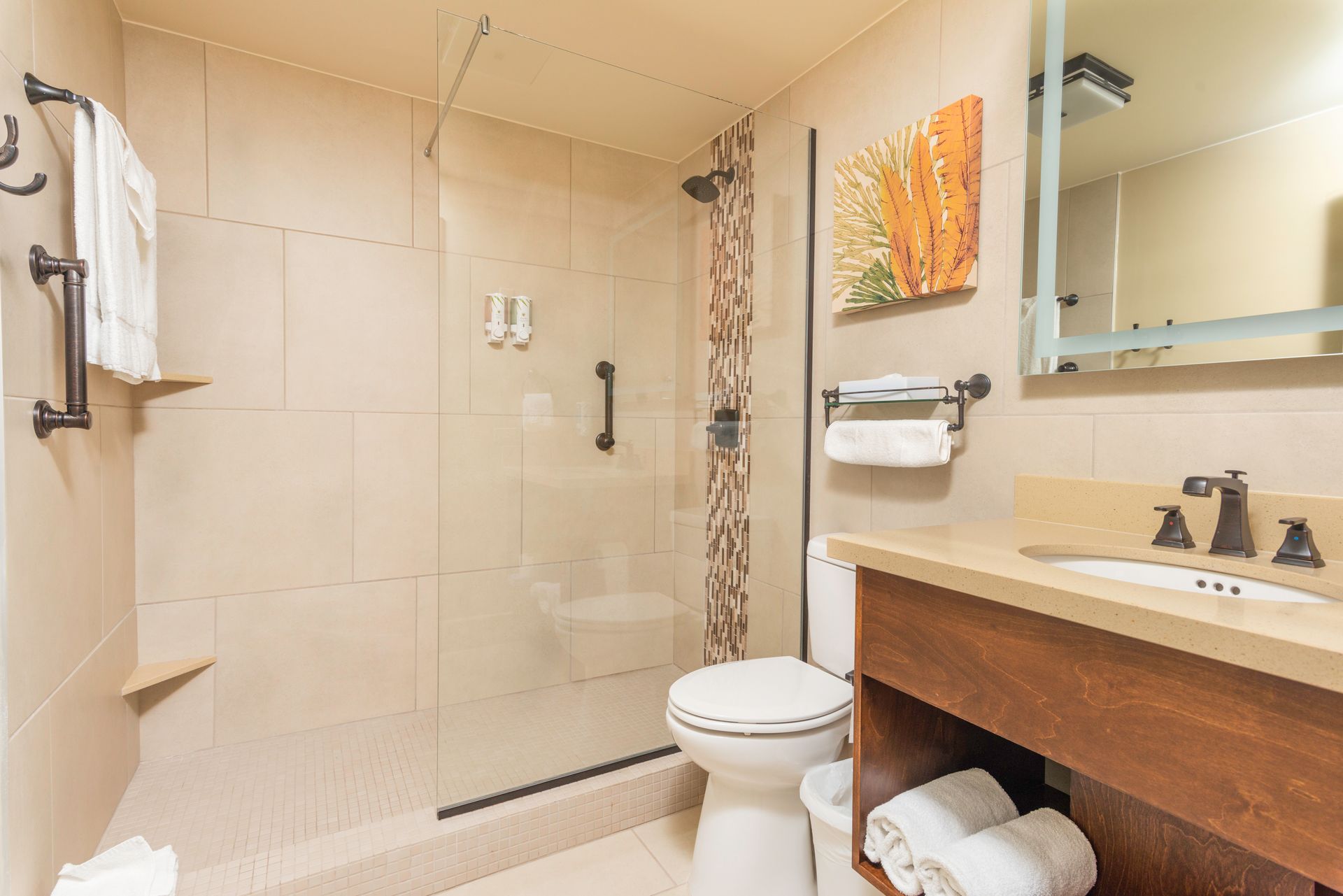 A bathroom in a hotel room with a toilet , sink and shower.