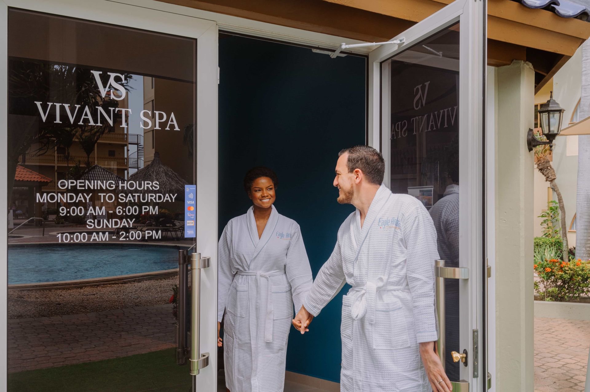 A man and a woman are holding hands while walking into a spa.