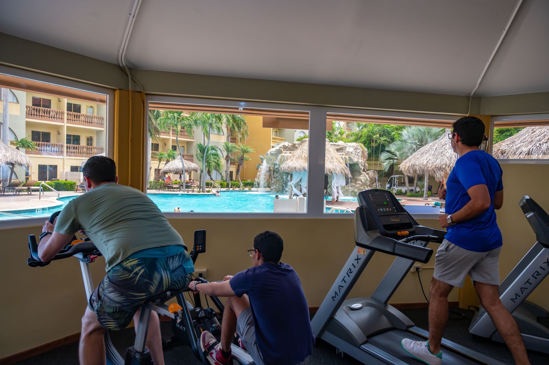 A woman is riding an elliptical machine in a gym.