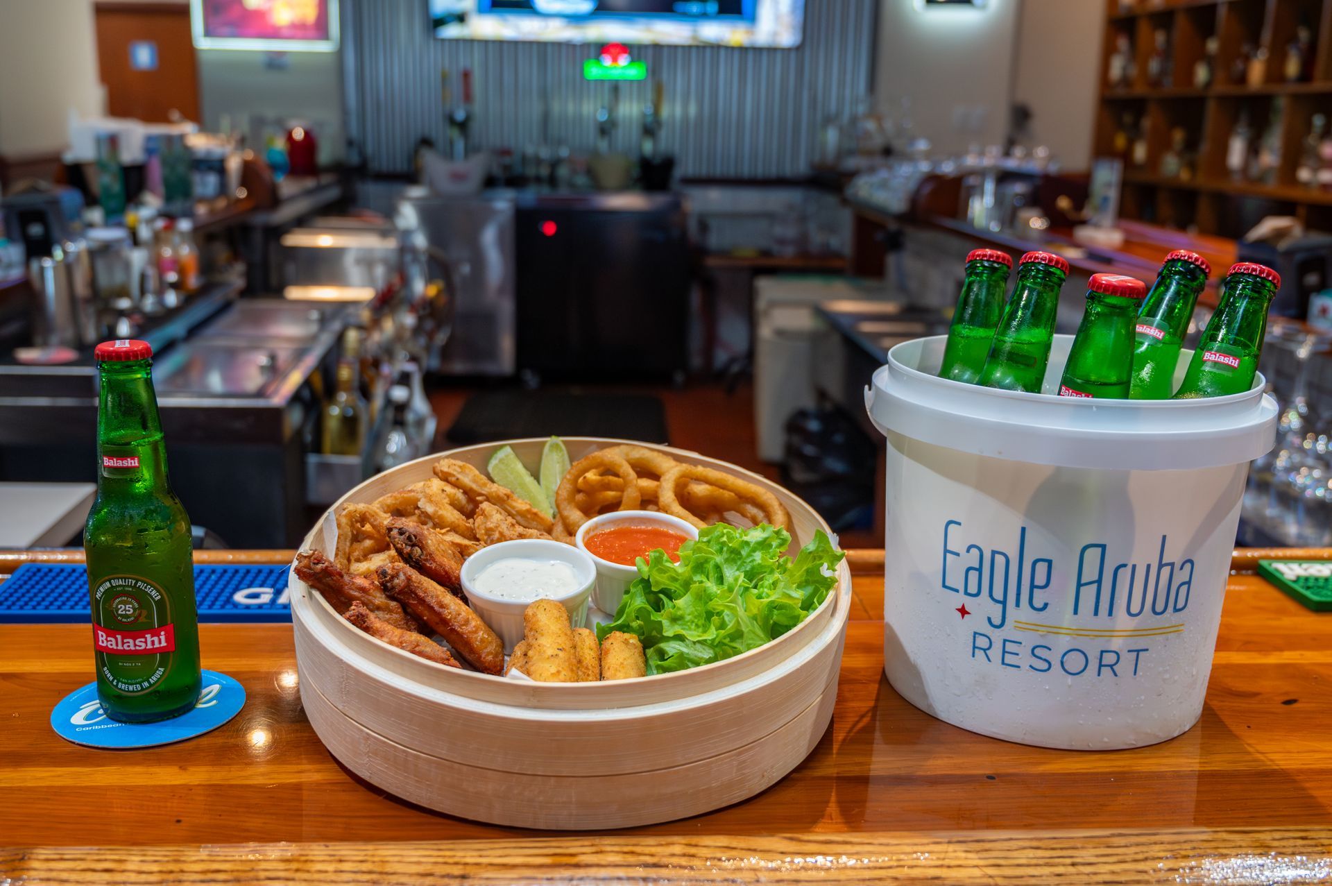 A bar with a bucket of beer and a plate of food on it.