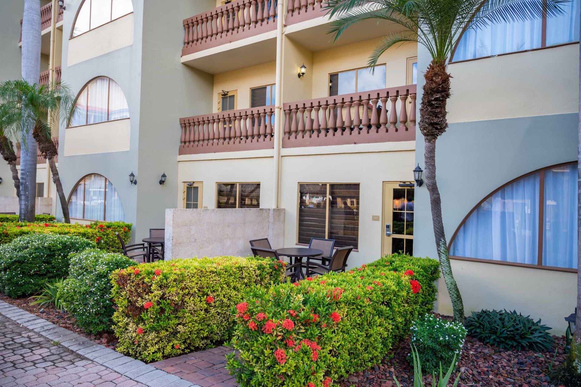 A building with a balcony and a table and chairs in front of it