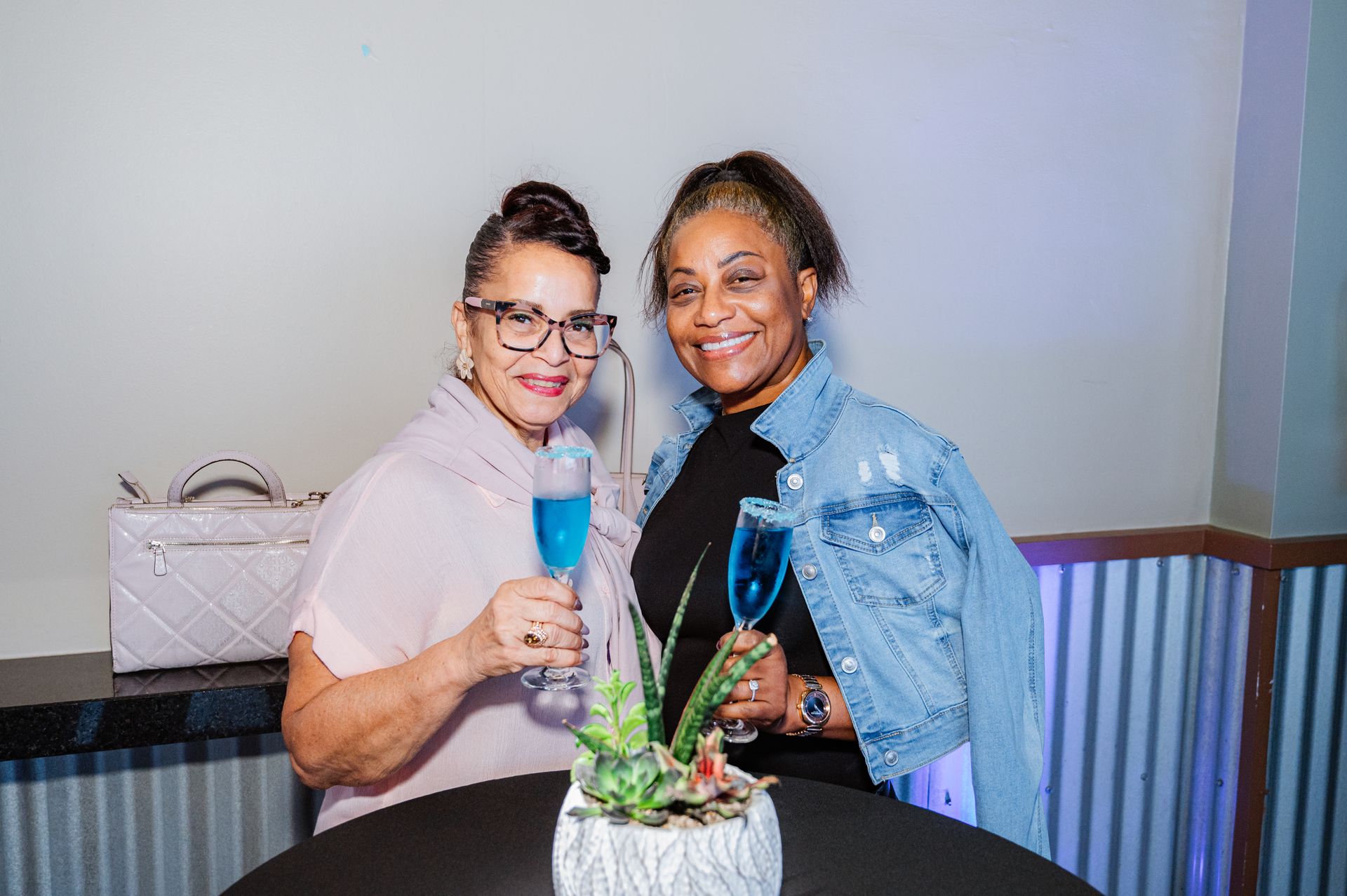 Two women are standing next to each other holding glasses of champagne.
