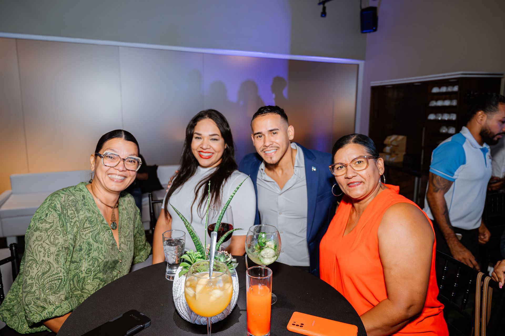 A group of people are sitting around a table with drinks.