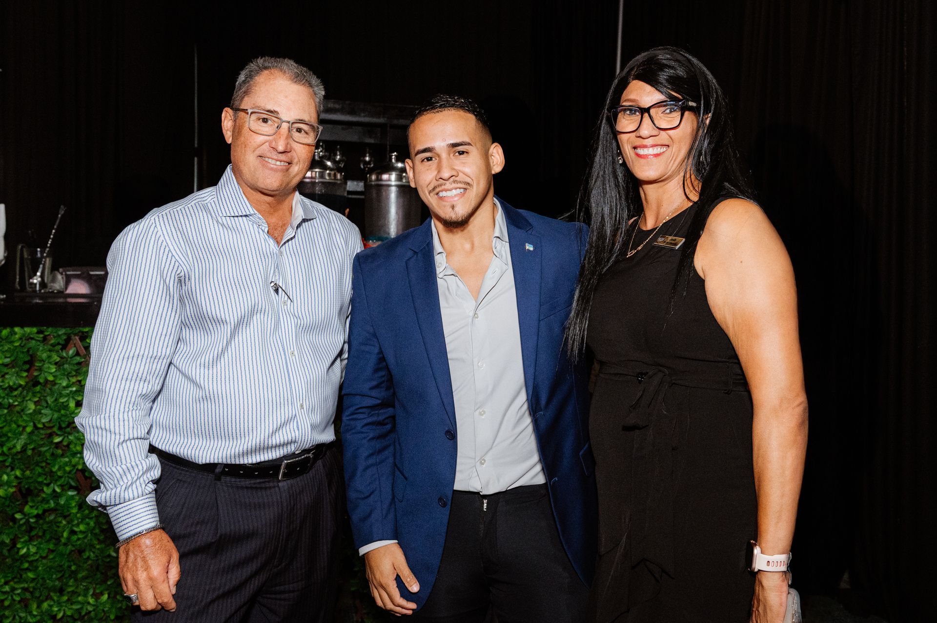 A man and two women are posing for a picture together.