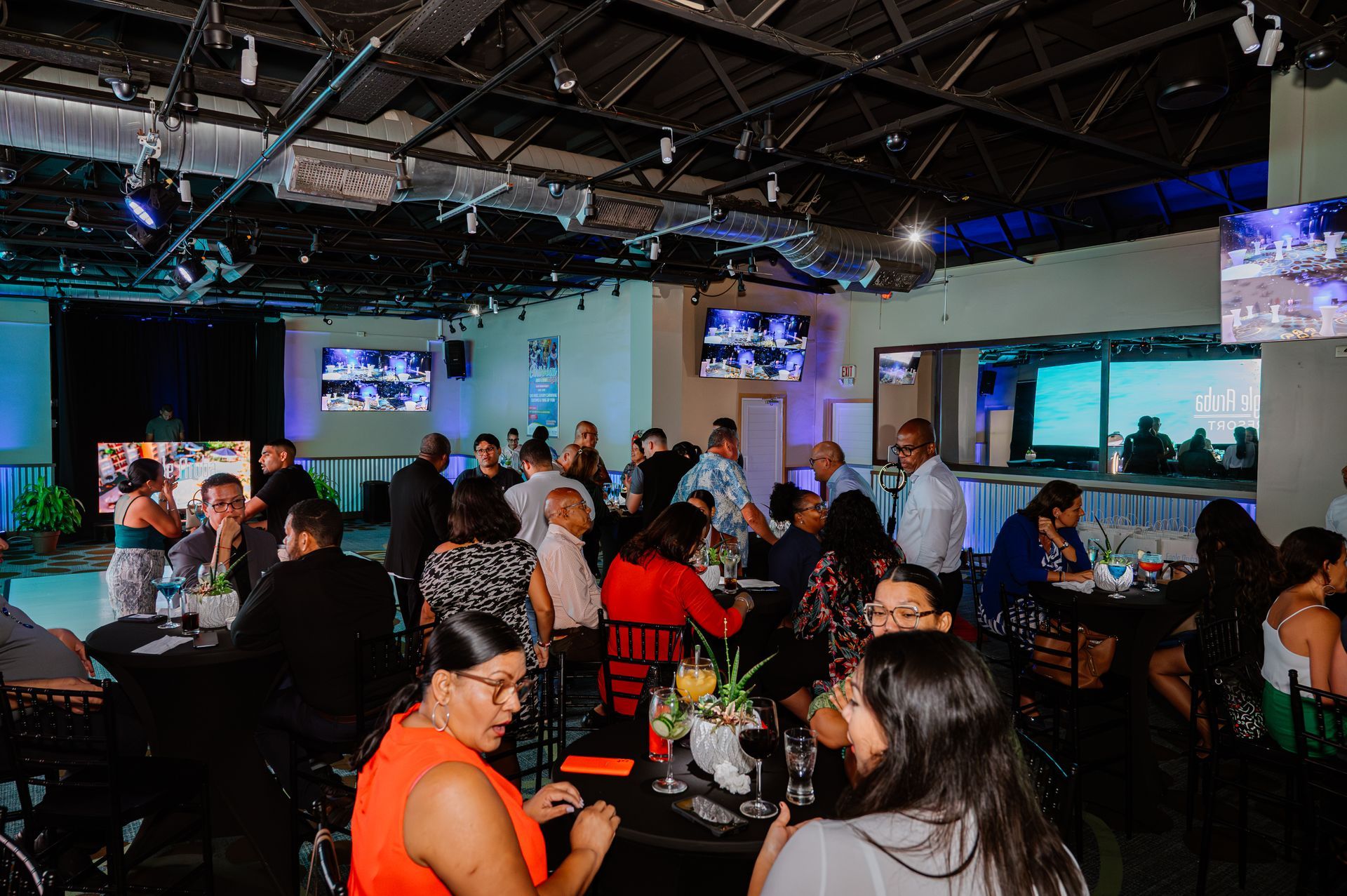 A large group of people are sitting at tables in a large room.
