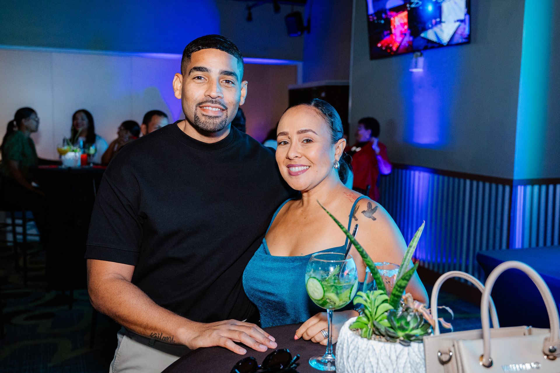 A man and a woman are posing for a picture in a restaurant.