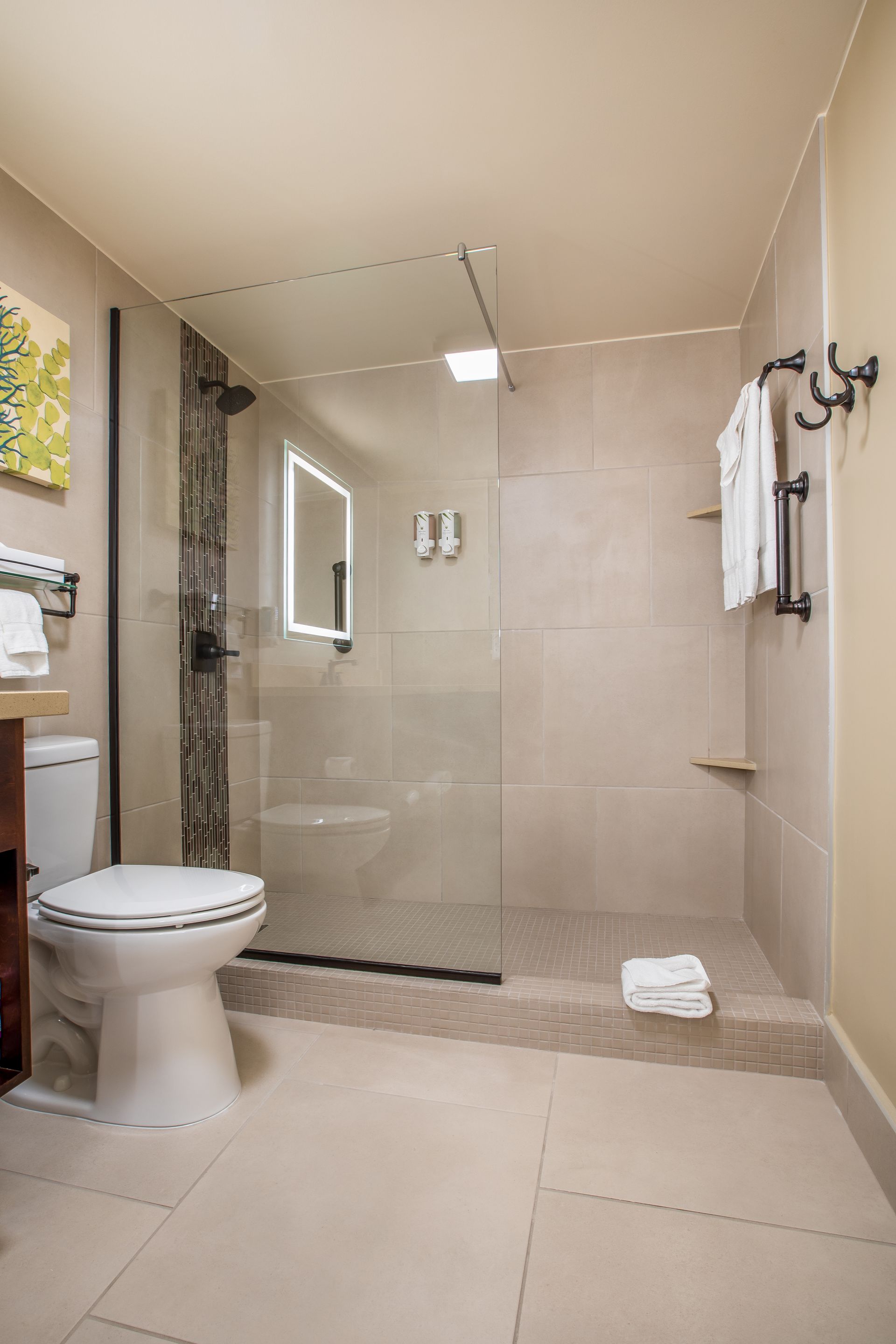 A bathroom with a toilet , sink , and walk in shower.