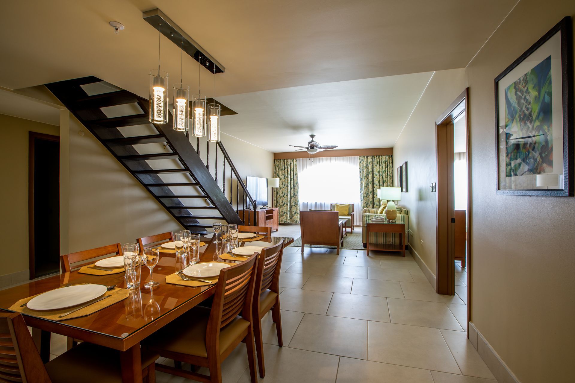 A dining room with a table and chairs and a staircase