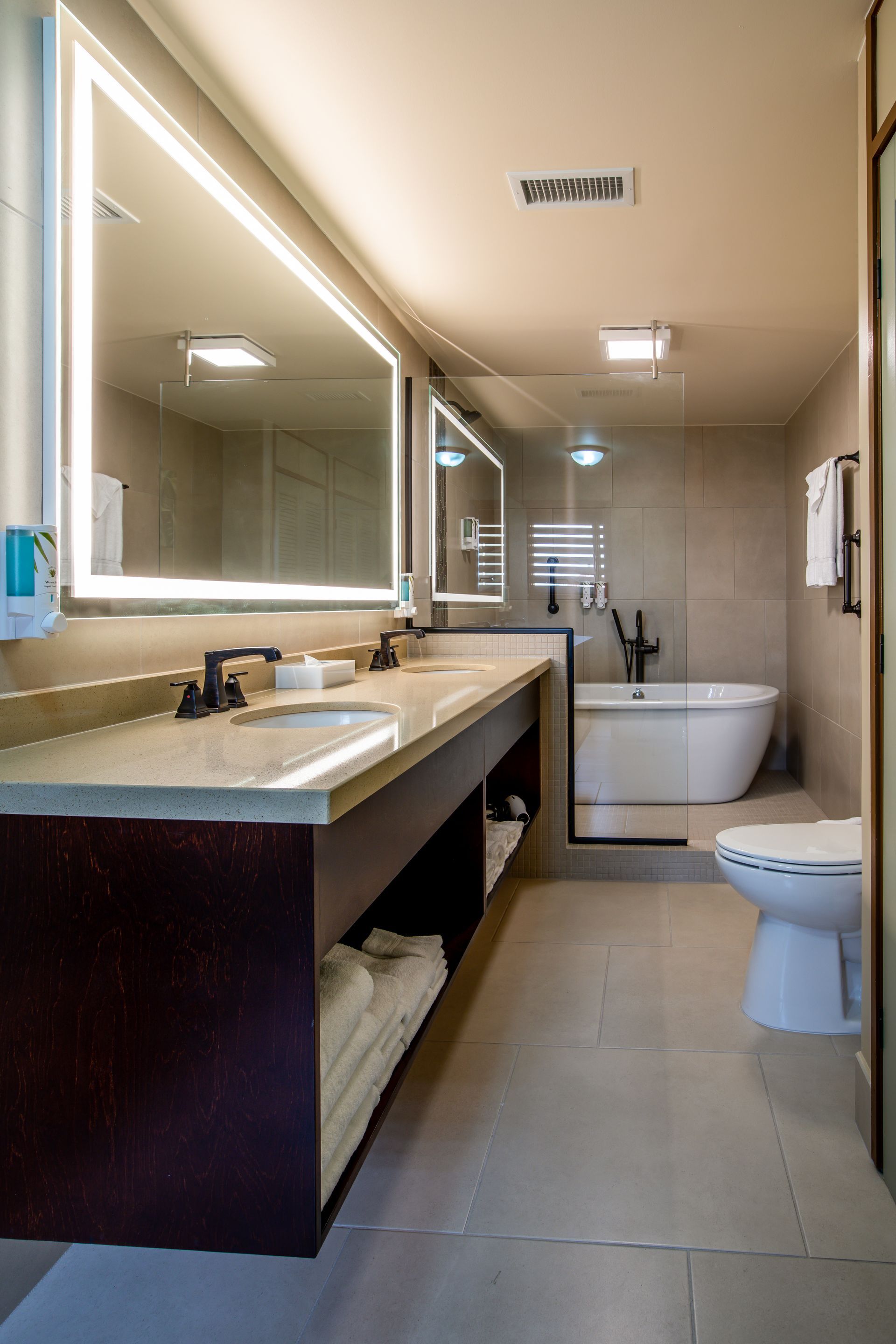 A bathroom with two sinks , a toilet , and a bathtub.