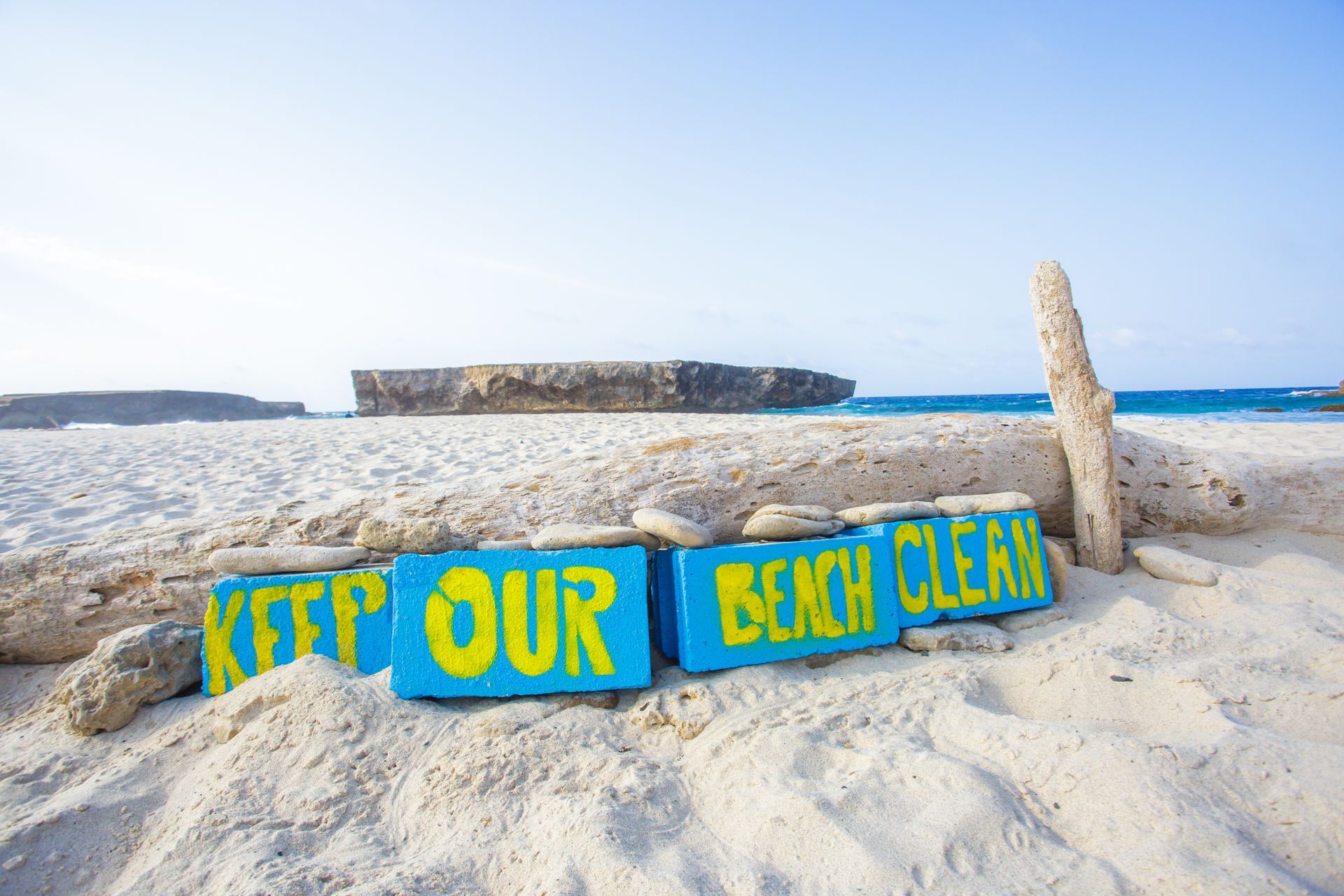 A beach with a sign that says keep our beach clean