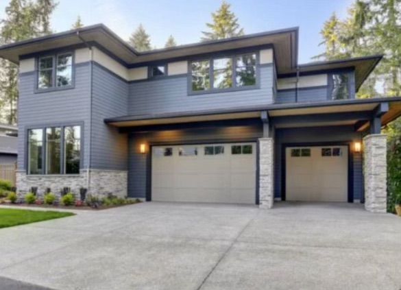 A large house with two garage doors and a concrete driveway