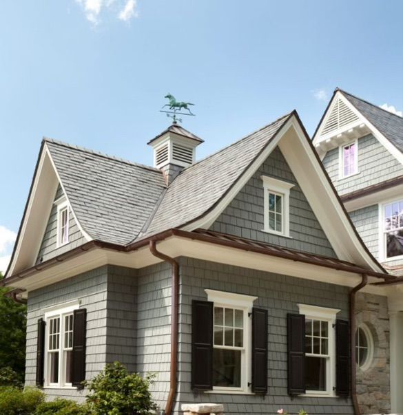 A house with a horse weather vane on top of it