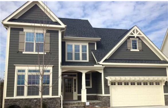 A gray house with white trim and a white garage door