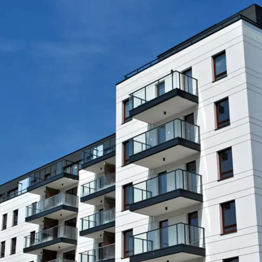 A white apartment building with balconies against a blue sky