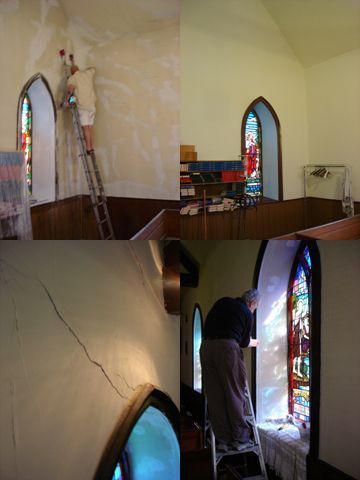 A man on a ladder painting a wall in a church