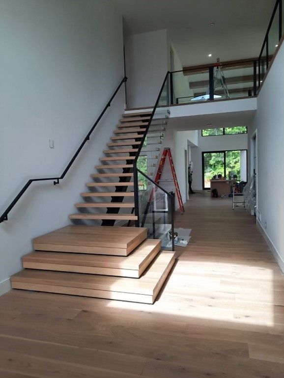 A wooden staircase with a glass railing in a house