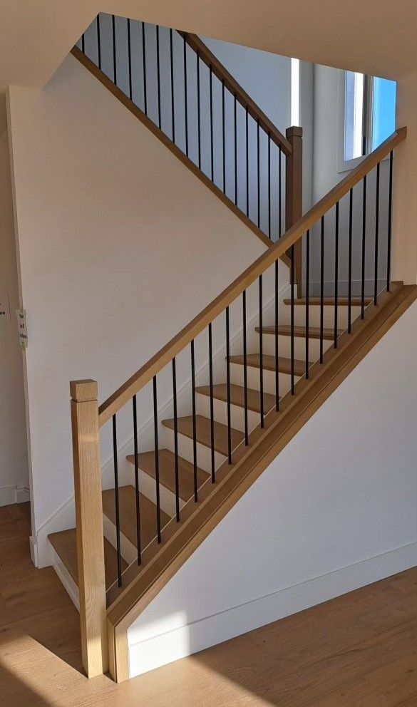 A wooden staircase with a metal railing in a house.