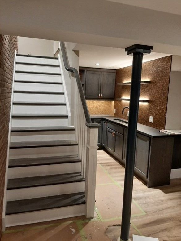 A staircase leading up to a kitchen in a basement.