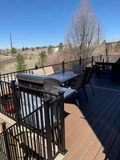 A deck with a table and chairs and a grill on it.