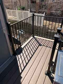 A balcony with a metal railing and a wooden deck.