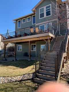 A large house with a deck and stairs leading up to it.