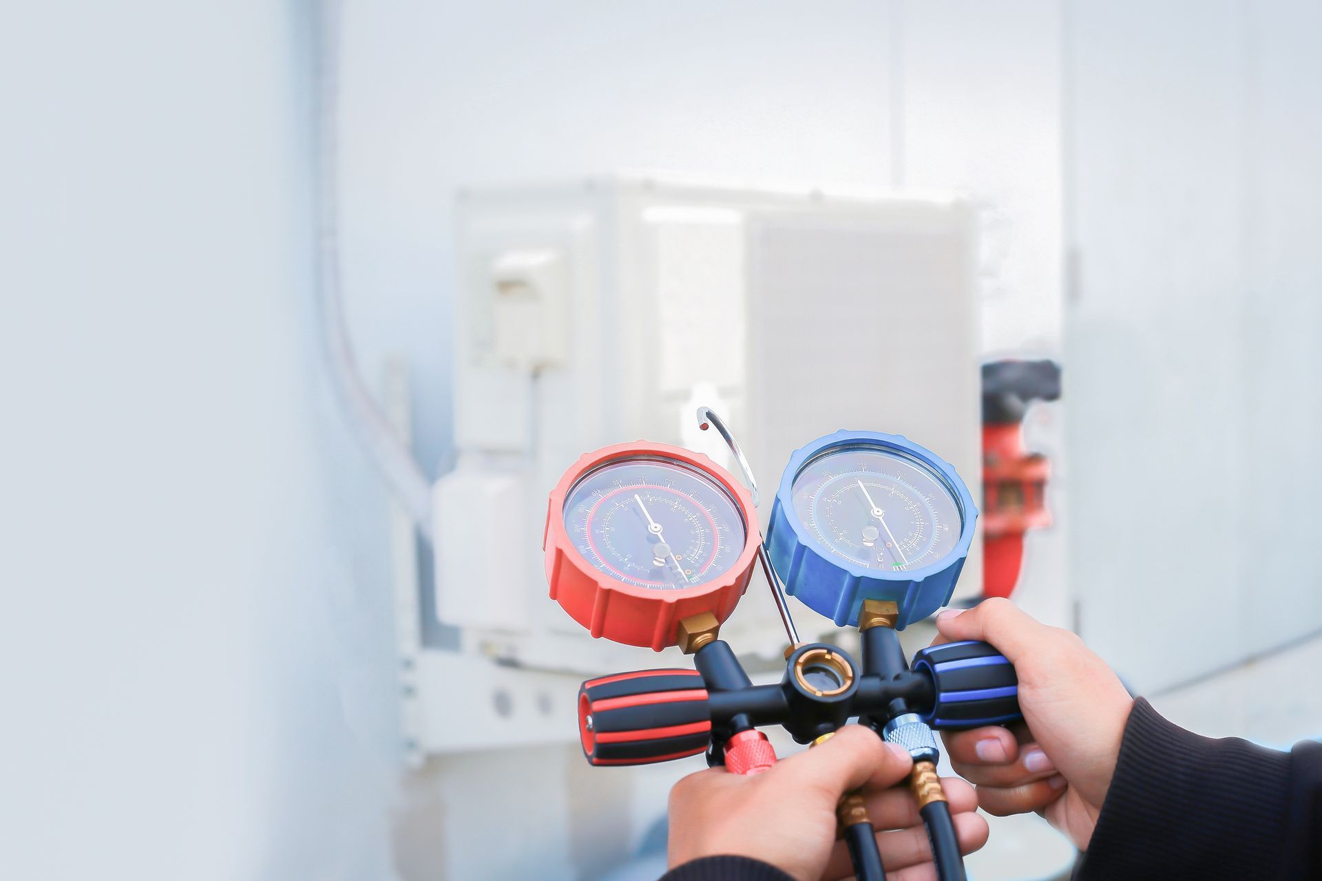 A person is holding a pressure gauge in their hands.