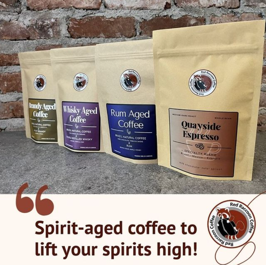 Four bags of spirit aged coffee are lined up next to each other