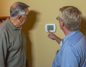 HVAC Inspections — Men Inspecting Thermostat in Nashville, TN