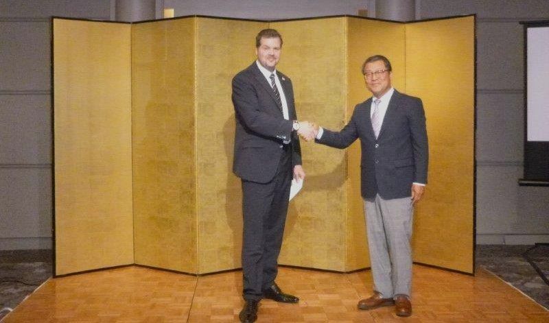 People pulling a large float with a wooden structure, in a city street during a festival.
