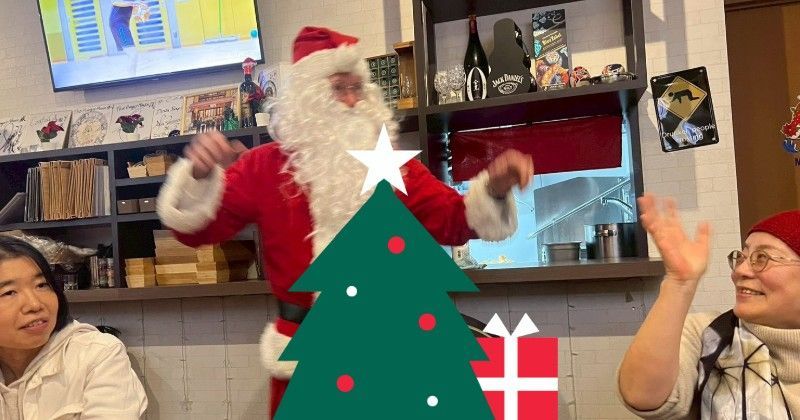 Santa Claus dancing in a restaurant with a woman waving. Christmas tree and present are illustrated in front.