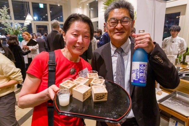 Guests serving Japanese sake during the international networking reception