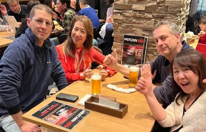 A group of people are sitting at a table drinking beer.