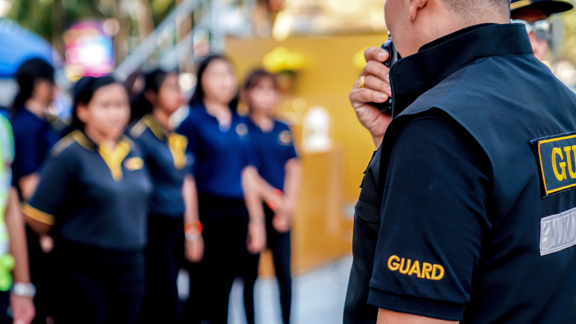 a man is talking on a walkie talkie in front of a group of people .