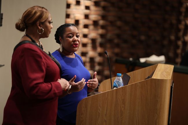 Philomena standing at a podium speaking at a business conference