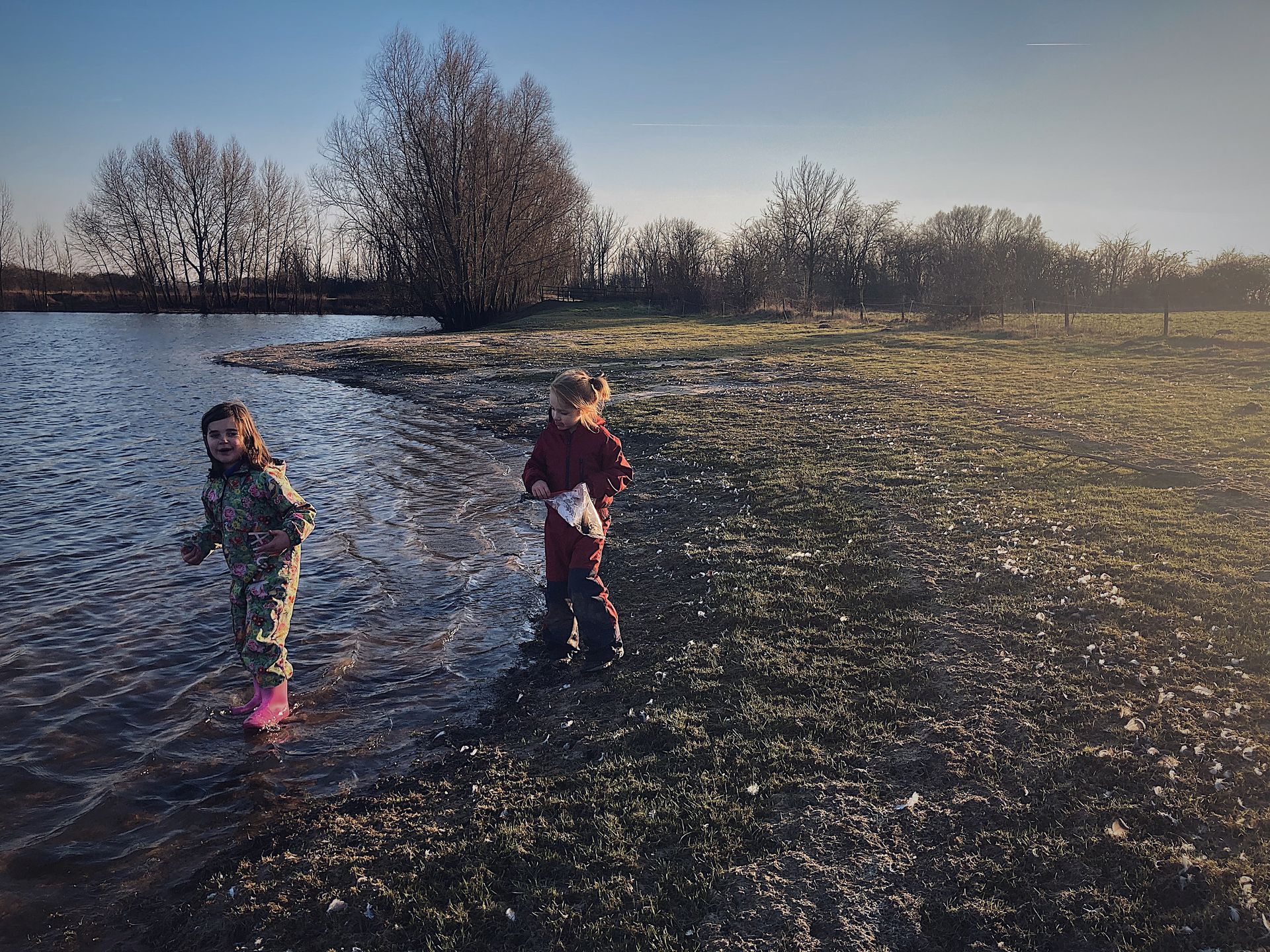 Twee kinderen verzamelen veren bij het meer – natuurbeleving en verwondering bij Willow BSO in Lathum
