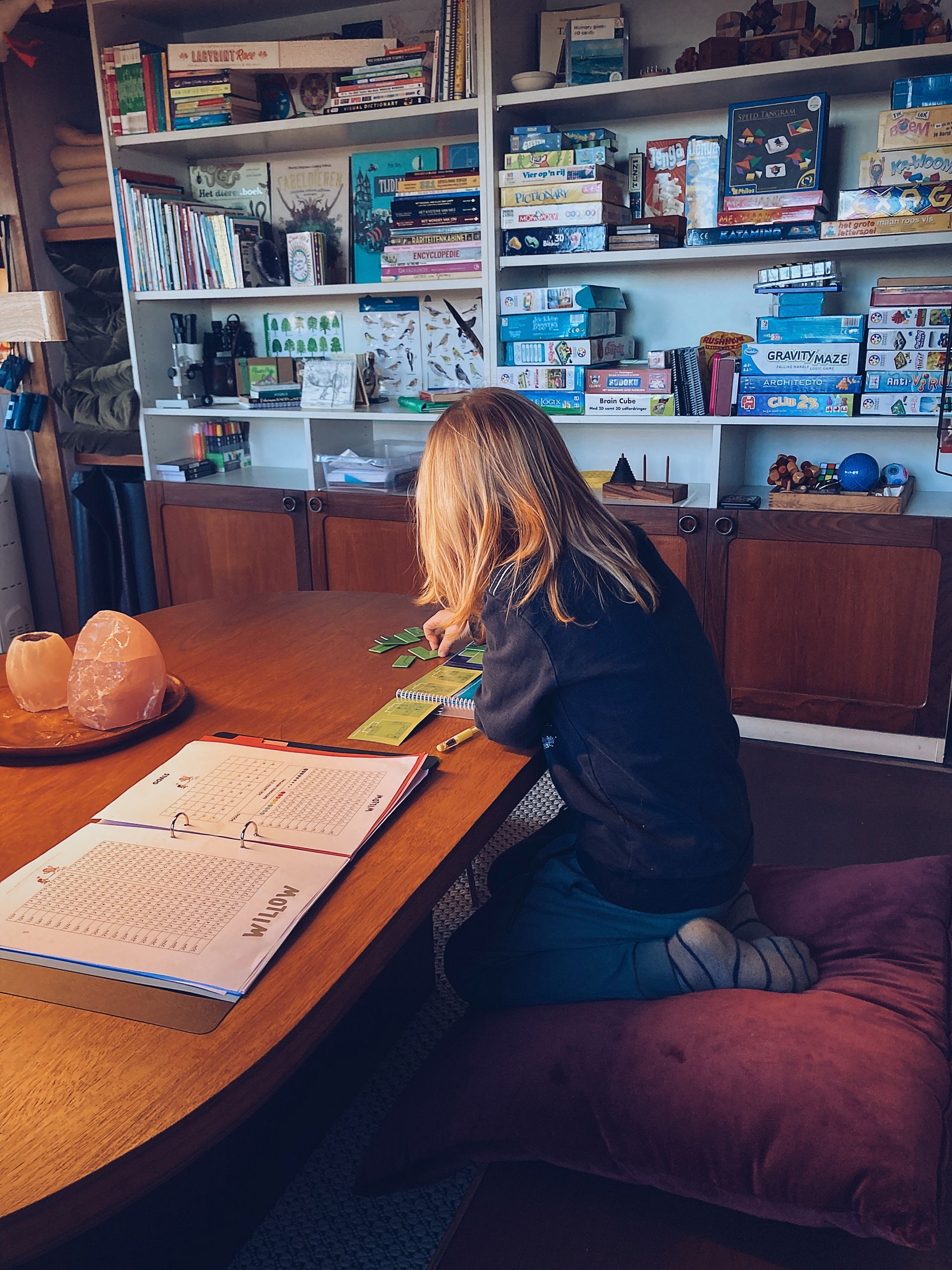 HB Jongen vult zijn map in en markeert zijn level in een slim spel – denksport en autonomie bij Willow BSO in Lathum, tussen de puzzels