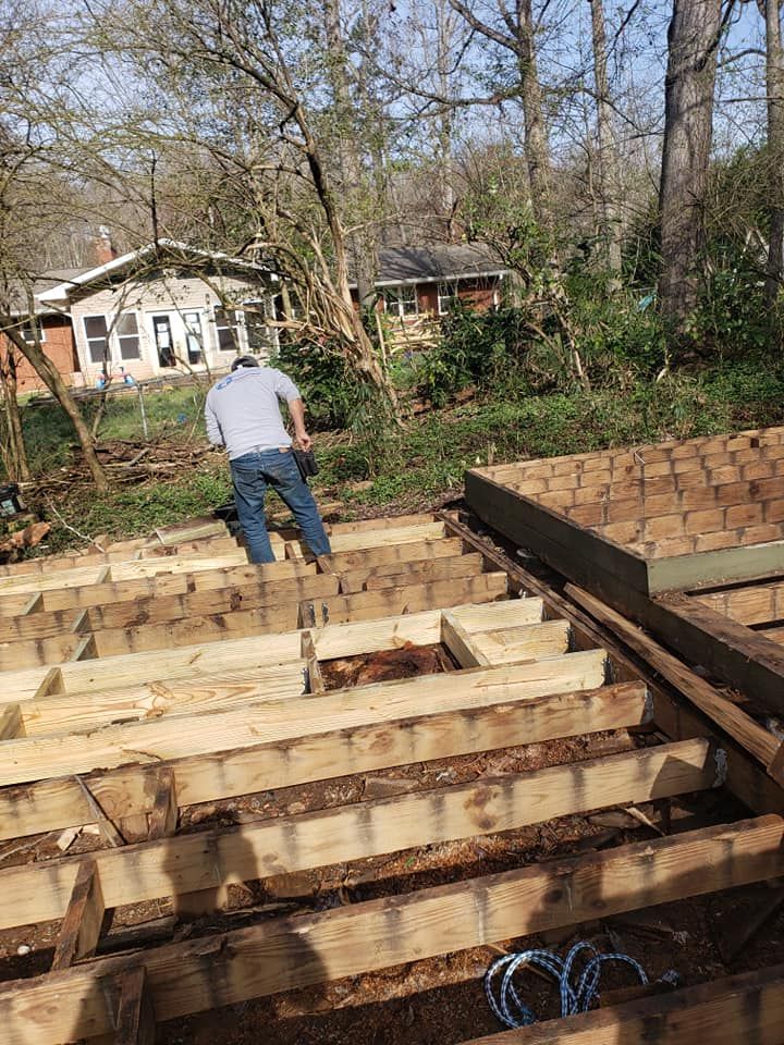 A man is standing on top of a wooden deck.