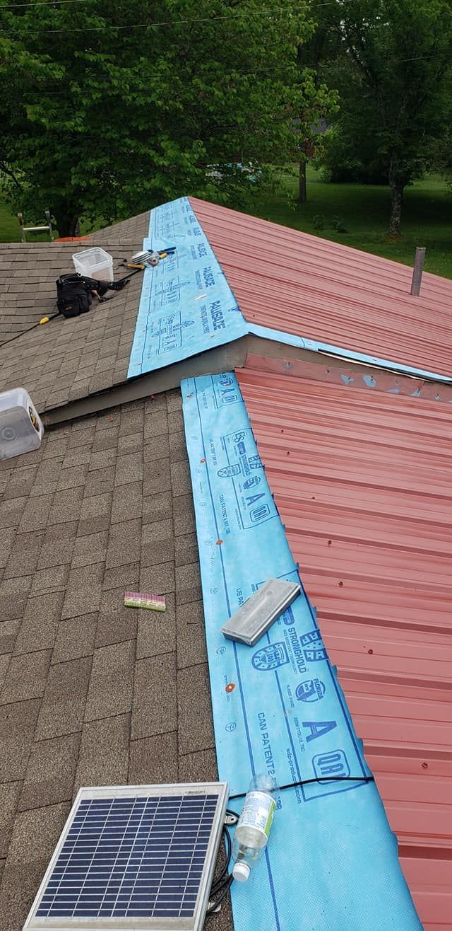 A solar panel is sitting on top of a red roof.